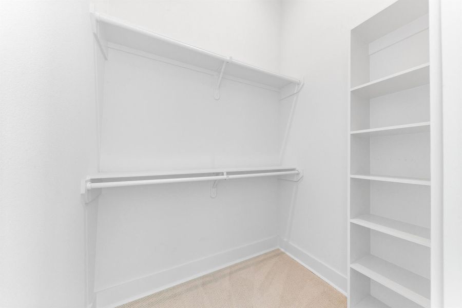 Walk-in closet with built-in shelves, providing organized storage and ample space for wardrobe essentials.