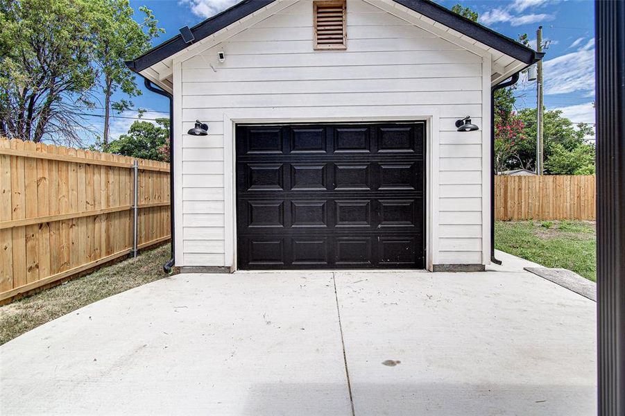 Detached garage featuring concrete driveway