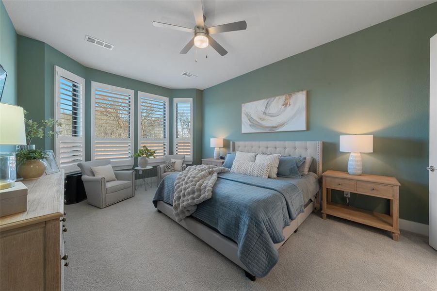 Carpeted bedroom with visible vents, ceiling fan, and baseboards