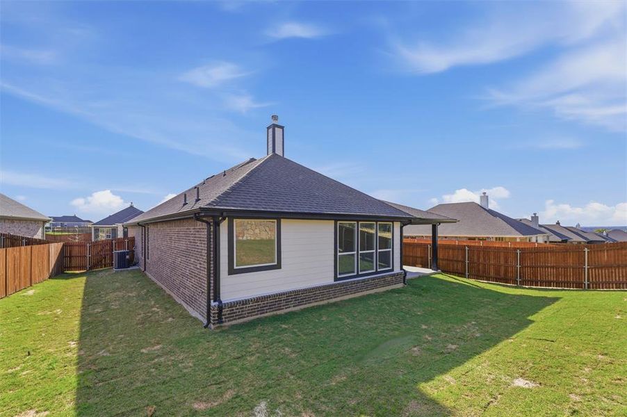 Back of house with a patio area, roof with shingles, a fenced backyard, and brick siding