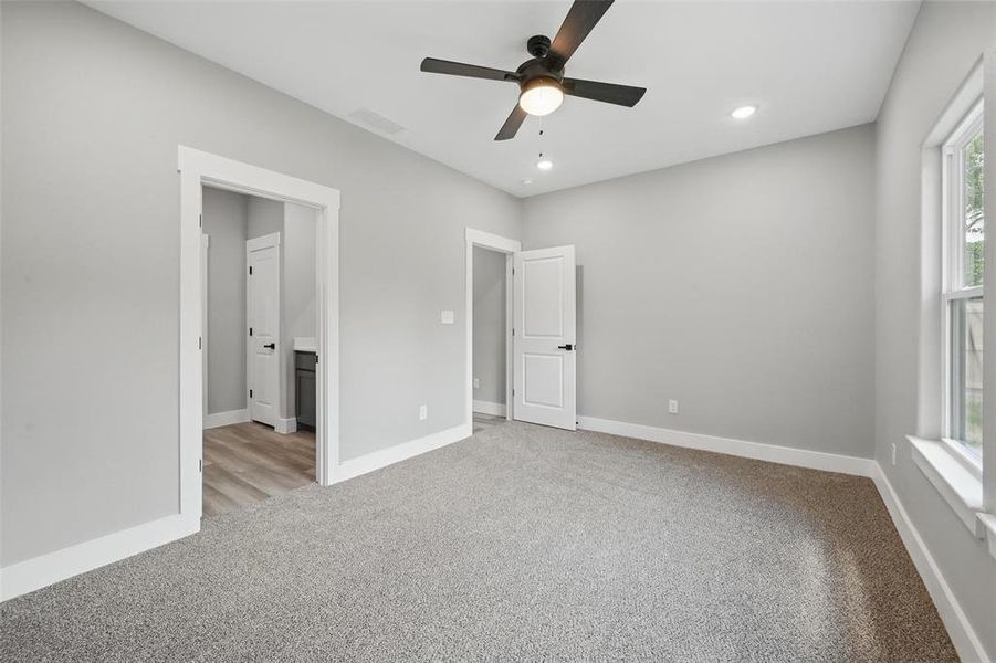 Unfurnished bedroom featuring light colored carpet, baseboards, recessed lighting, and ceiling fan