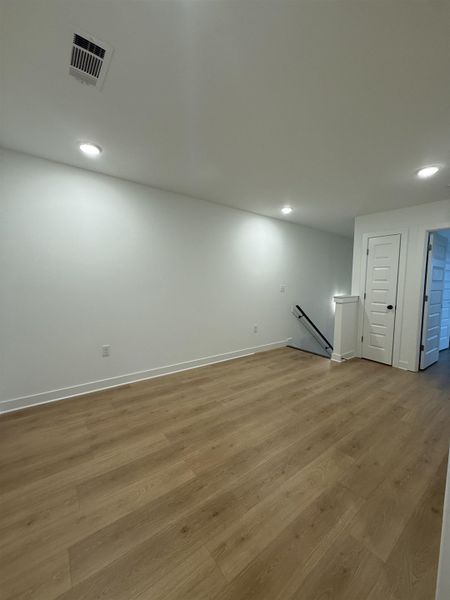 Basement with wood finished floors and recessed lighting