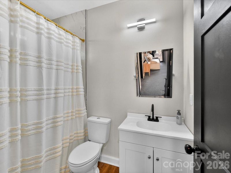 Clean and inviting full bathroom featuring a modern vanity, sleek fixtures, and a classic tub-shower combo with stylish accents.