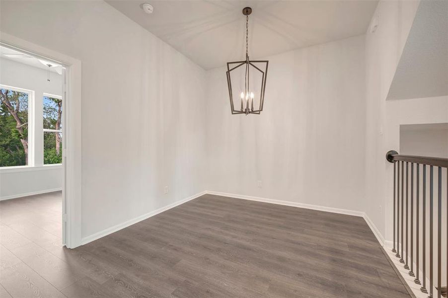 Interior space featuring wood-finish flooring, white walls, and a contemporary geometric chandelier Interior space featuring wood-finish flooring, white walls, and a contemporary geometric chandelier