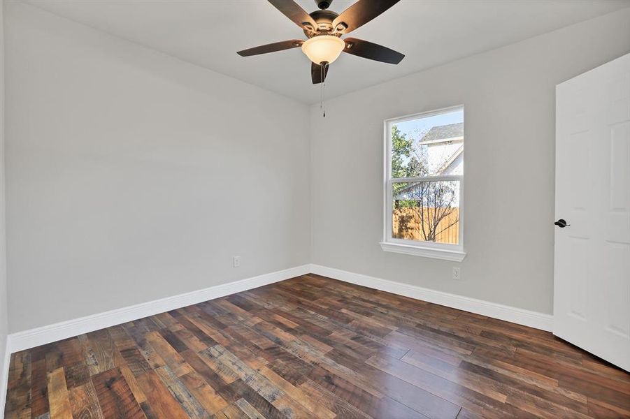 Spare room with dark hardwood / wood-style floors and ceiling fan