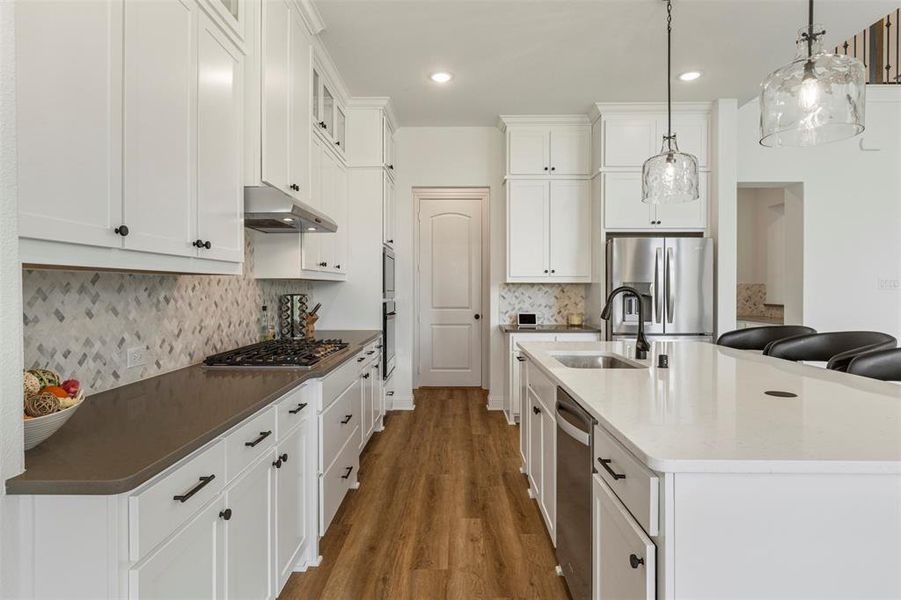 Kitchen with a breakfast bar area, white cabinets, appliances with stainless steel finishes, and recessed lighting Kitchen with a breakfast bar area, white cabinets, appliances with stainless steel finishes, and recessed lighting