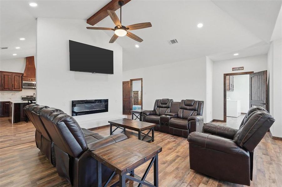 Living area with recessed lighting, beam ceiling, ceiling fan, light wood-type flooring, and a glass covered fireplace Living area with recessed lighting, beam ceiling, ceiling fan, light wood-type flooring, and a glass covered fireplace