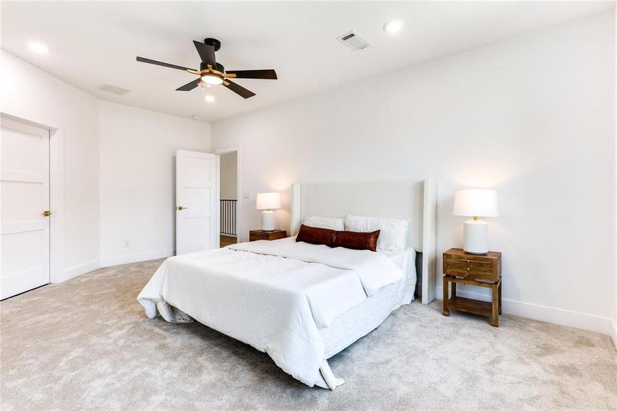 Carpeted bedroom featuring ceiling fan