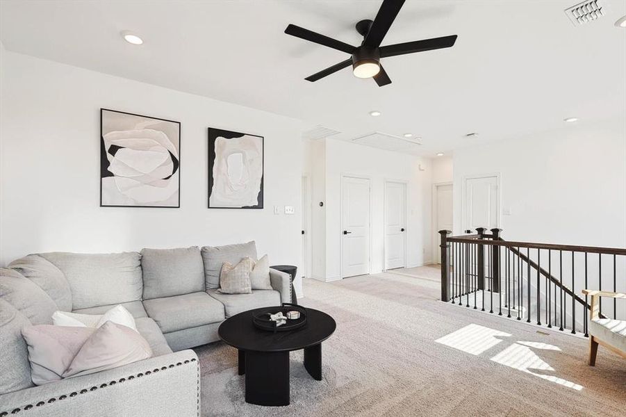 Carpeted living room featuring ceiling fan