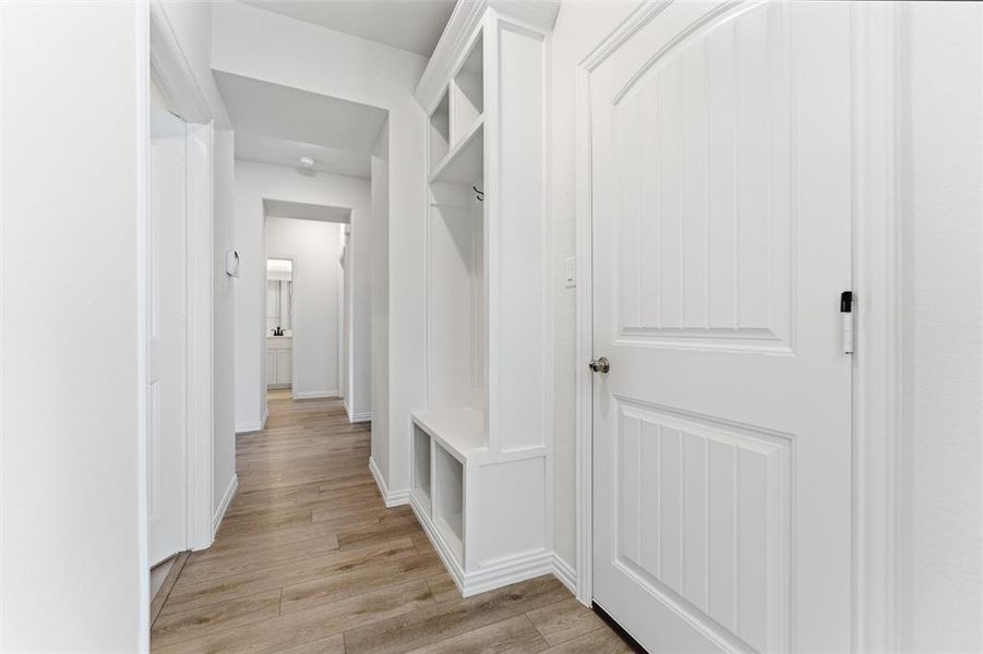 Mudroom featuring light wood-style floors and baseboards