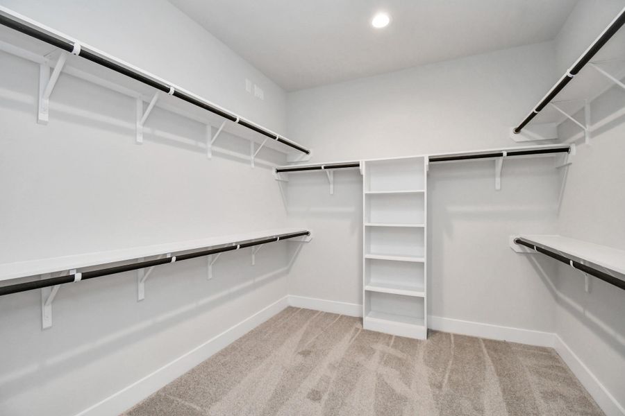 Walk-in closet that epitomizes luxury and practicality. This generously sized space features built-in shelving, offering abundant room for impeccable organization. High ceilings and recessed lighting create a bright and welcoming ambiance. Sample photo of completed home with similar floor plan. Actual colors and selections may vary. Walk-in closet that epitomizes luxury and practicality. This generously sized space features built-in shelving, offering abundant room for impeccable organization. High ceilings and recessed lighting create a bright and welcoming ambiance. Sample photo of completed home with similar floor plan. Actual colors and selections may vary.