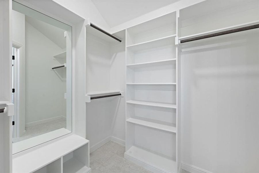 Walk in closet with vaulted ceiling and light tile patterned floors