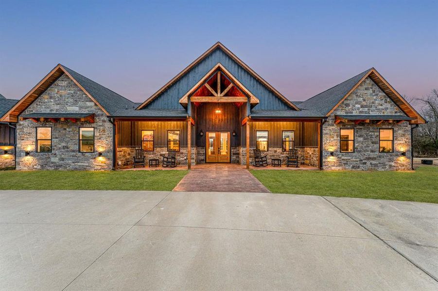 Craftsman house with stone siding, covered porch, and a front yard