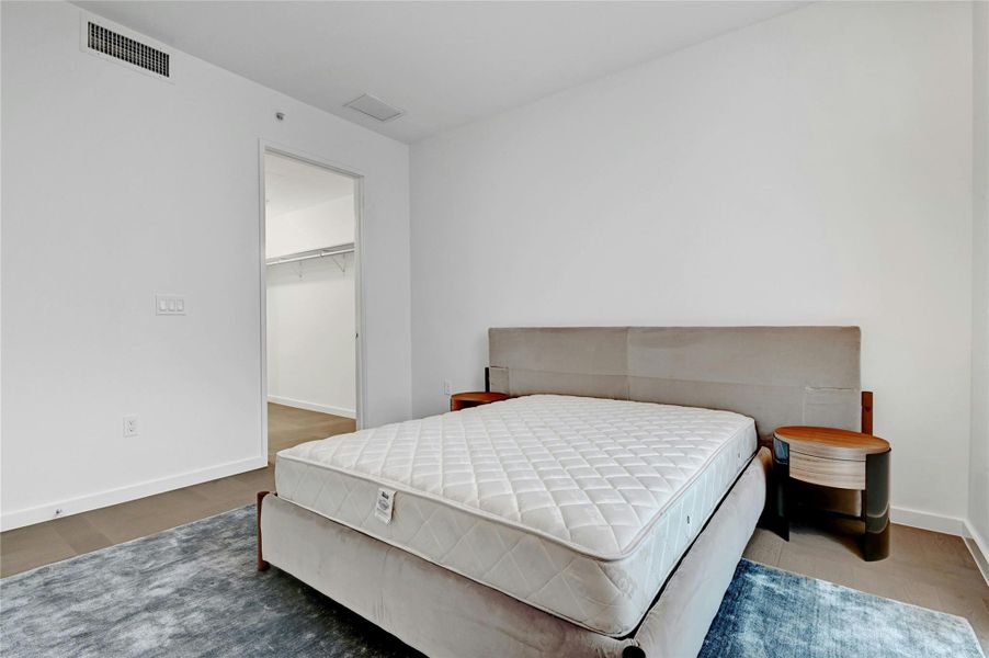 Step into this sleek and contemporary bedroom featuring floor-to-ceiling windows that frame spectacular views of the city and beyond. Furnishings provided by Scott + Cooner available for purchase separately. Photo is model unit #2406.
