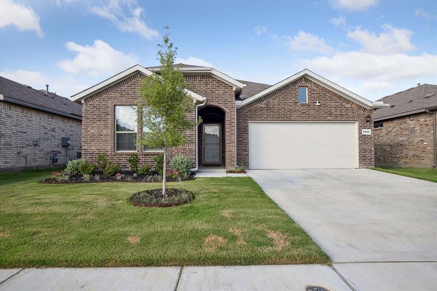 View of front of property featuring a garage and a front yard View of front of property featuring a garage and a front yard