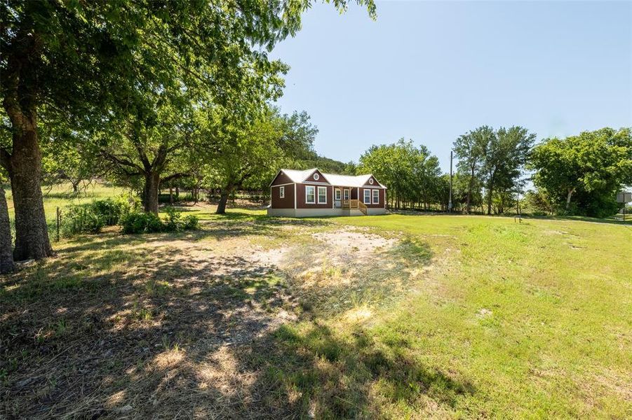 Red exterior residence featuring a white-trimmed gable roof, multiple windows, and a raised wooden porch