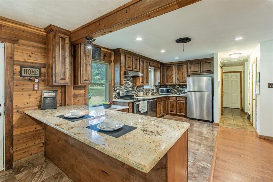 Updated kitchen with granite countertops, custom cabinetry, and an open flow into the dining area. Updated kitchen with granite countertops, custom cabinetry, and an open flow into the dining area.