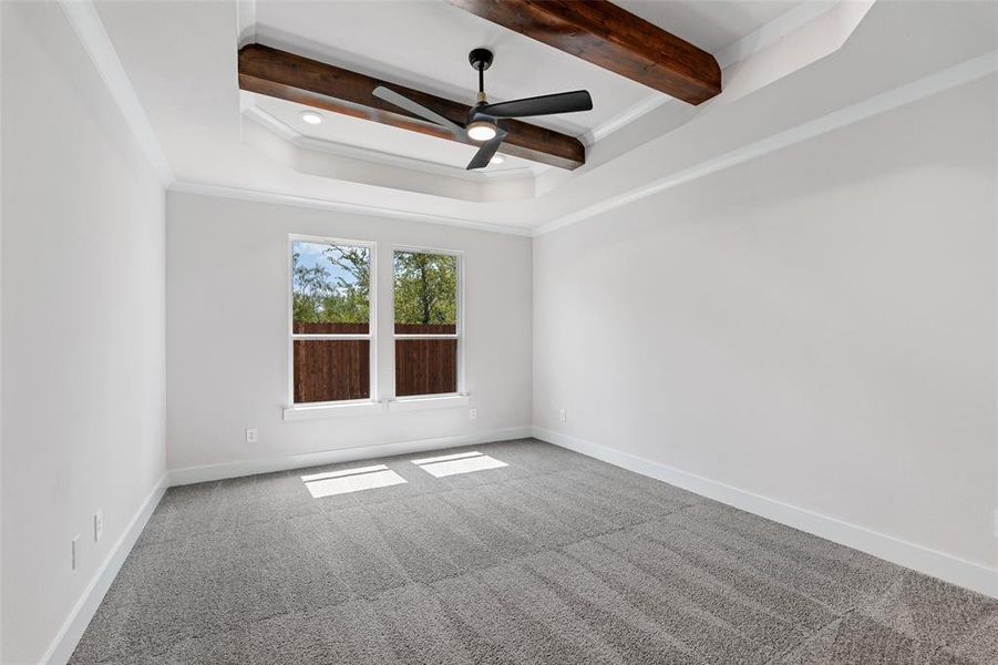 Spare room with crown molding, carpet flooring, ceiling fan, and beam ceiling