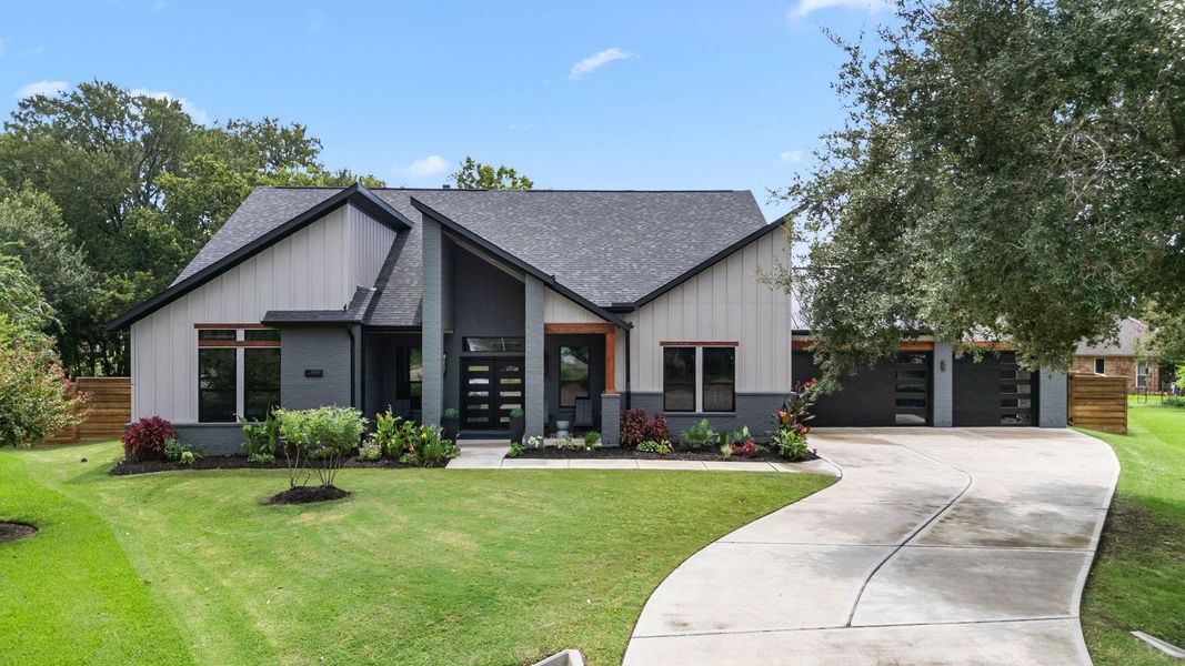 This modern home features a sleek exterior with a combination of dark and light siding, large windows for natural light, and a well-maintained lawn. The curved driveway leads to a spacious garage, and the front yard is landscaped with plants and shrubs, offering great curb appeal. This modern home features a sleek exterior with a combination of dark and light siding, large windows for natural light, and a well-maintained lawn. The curved driveway leads to a spacious garage, and the front yard is landscaped with plants and shrubs, offering great curb appeal.