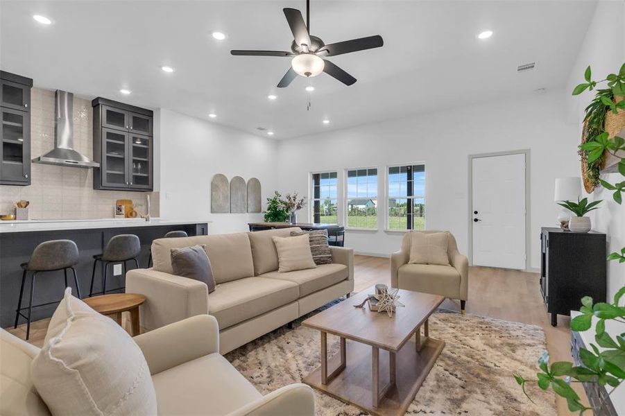 Living room featuring wood finished floors, recessed lighting, and a ceiling fan Living room featuring wood finished floors, recessed lighting, and a ceiling fan