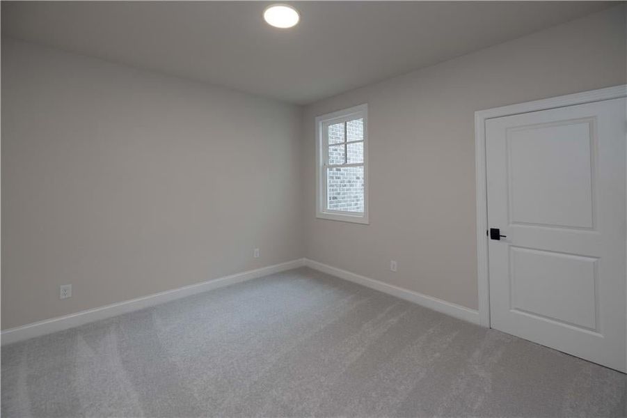 Spare room with light carpet and baseboards