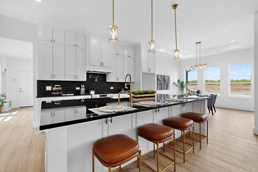 Kitchen featuring light wood-type flooring, white cabinetry, pendant lighting, recessed lighting, and a raised ceiling