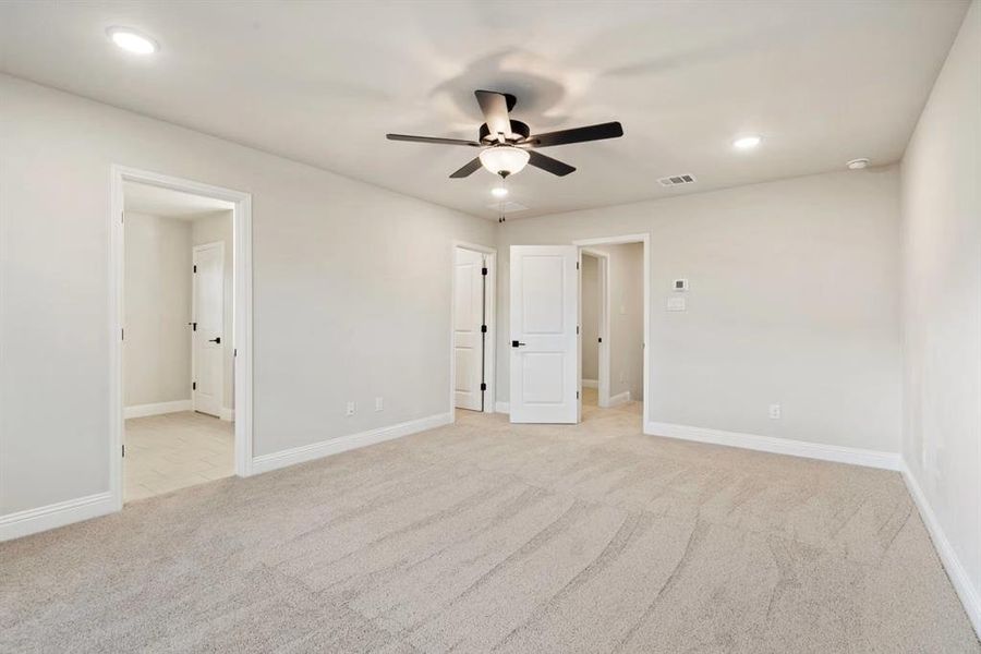 Unfurnished room featuring light carpet and ceiling fan