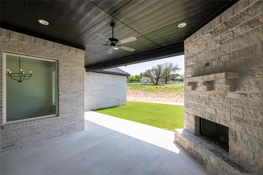 View of patio / terrace featuring an outdoor stone fireplace and ceiling fan