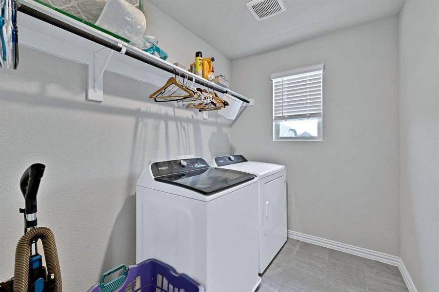 The property includes a laundry area with a washer and dryer, a window with blinds, and shelving for storage