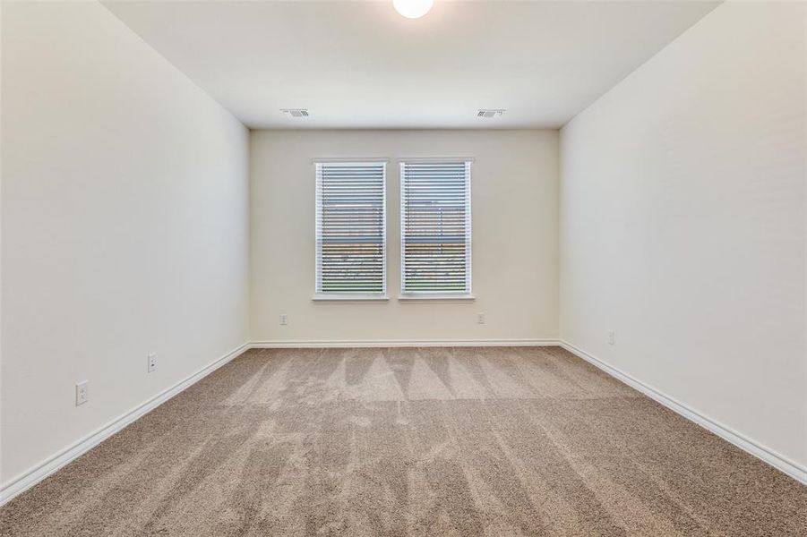 Empty room featuring light colored carpet and baseboards Empty room featuring light colored carpet and baseboards