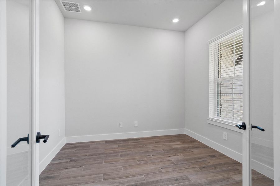 Tucked peacefully in the front of the home is this Study. The Study offers a quiet workspace with tile flooring, high ceilings, double French doors for added privacy, large window with fitted blinds, and custom paint for a polished finish.