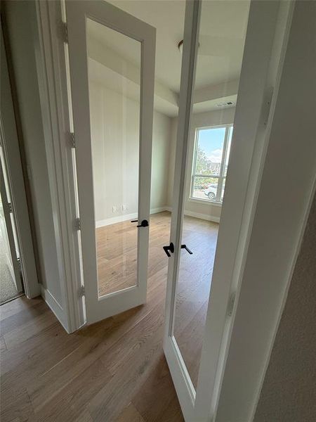 Corridor featuring light wood-style flooring and baseboards Corridor featuring light wood-style flooring and baseboards