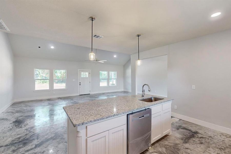 Kitchen with ceiling fan, sink, a center island with sink, dishwasher, and white cabinetry