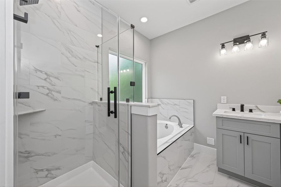 Modern, spa-like primary bathroom with high-end finishes and a clean, elegant design. Black round mirrors are being installed.