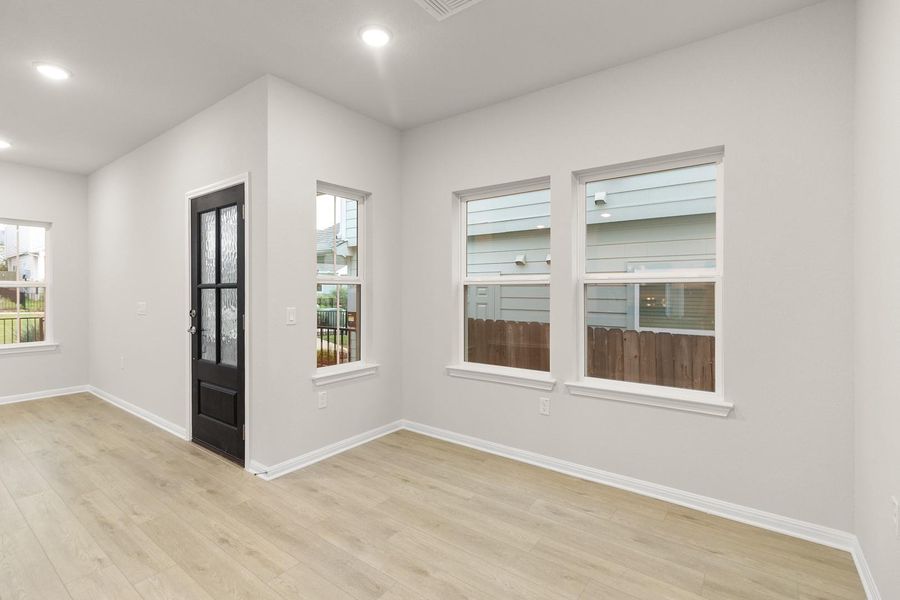 The interior features light-colored flooring, white walls, recessed lighting, and windows that provide views of the surrounding area