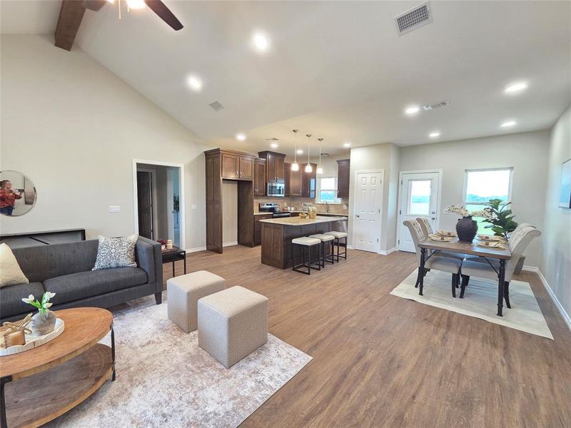 Living room with light wood-style floors, recessed lighting, beamed ceiling, a ceiling fan, and high vaulted ceiling Living room with light wood-style floors, recessed lighting, beamed ceiling, a ceiling fan, and high vaulted ceiling