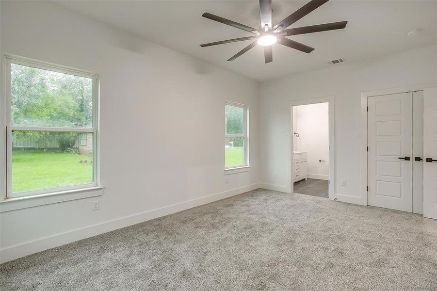 Unfurnished bedroom with carpet floors, ensuite bath, a closet, and ceiling fan
