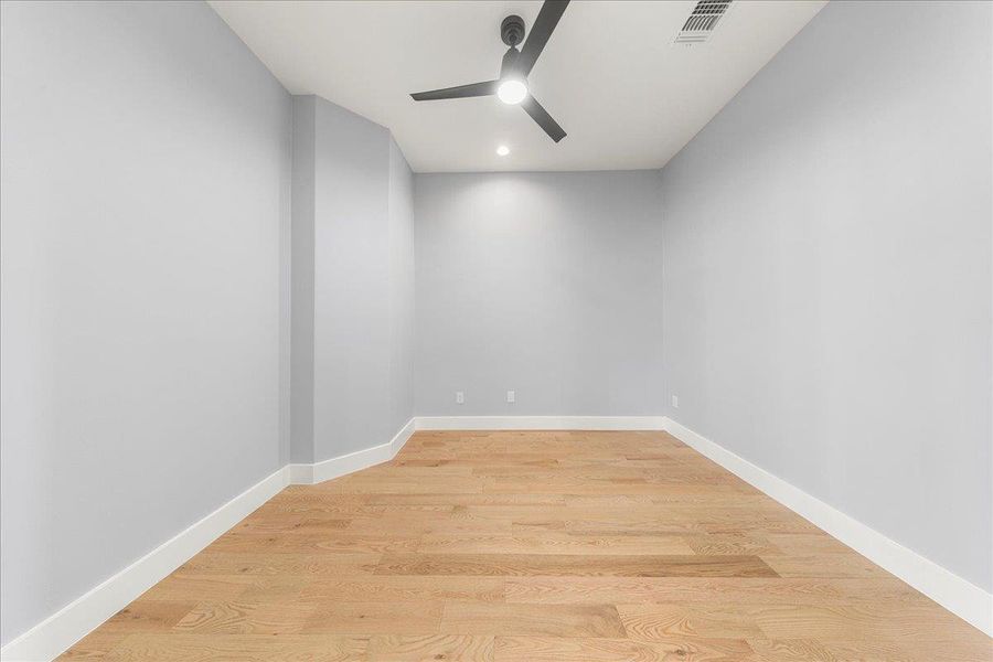 Empty room featuring light wood finished floors and ceiling fan Empty room featuring light wood finished floors and ceiling fan
