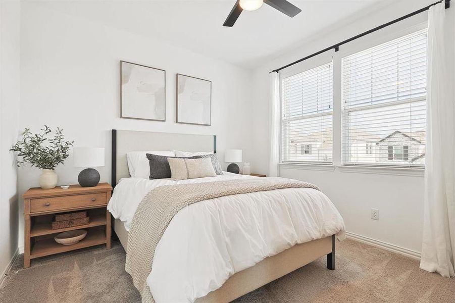 Carpeted bedroom featuring ceiling fan