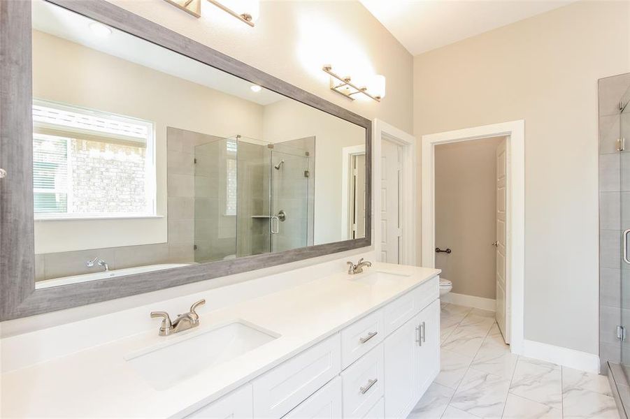 Bathroom featuring vanity, a shower with door, and toilet