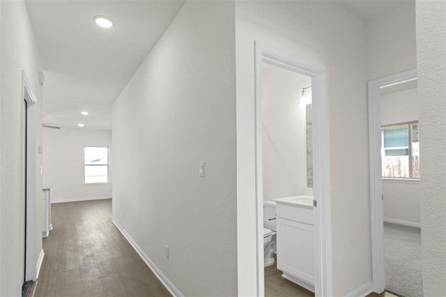Corridor with recessed lighting, wood finished floors, and baseboards