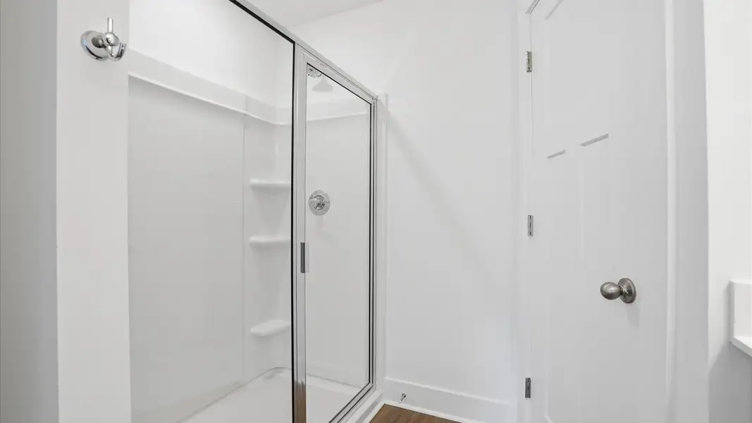 Memorable mornings begin in this elegant primary bathroom with walk-in shower and hardwood flooring at Marion Square