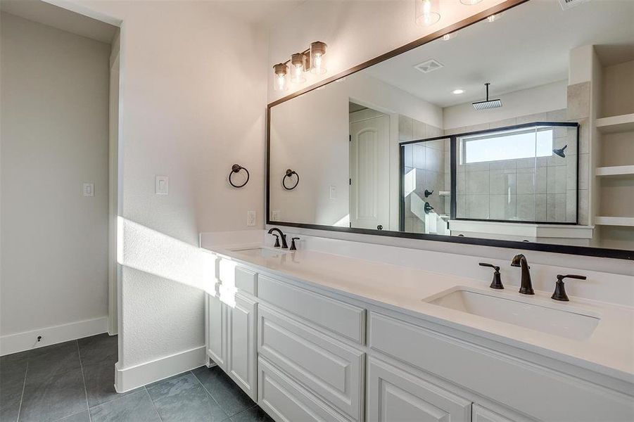 Bathroom with tile patterned flooring, vanity, and walk in shower