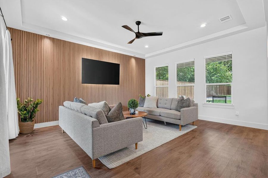 Contemporary living space featuring a wood-panel accent wall with integrated backlighting