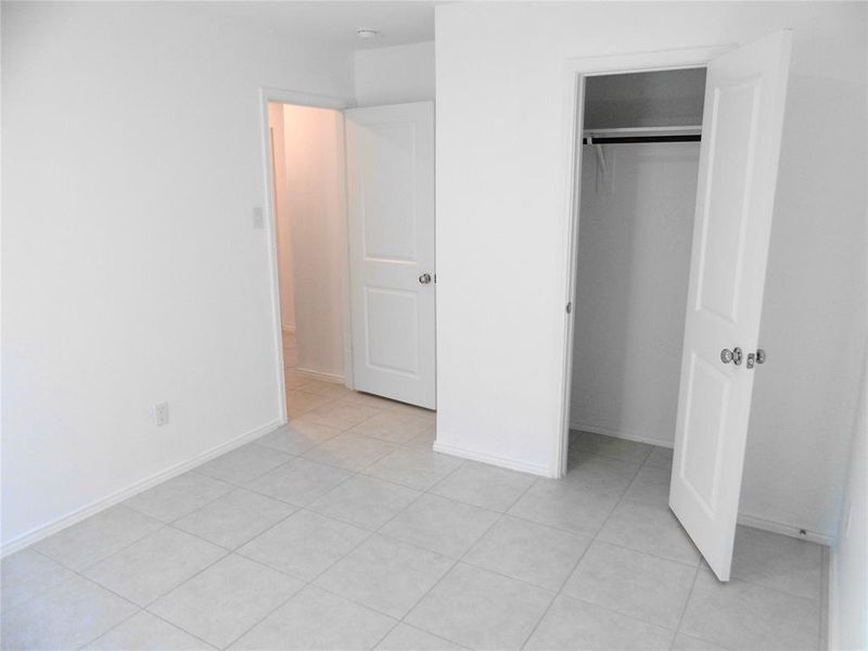 Unfurnished bedroom featuring light tile patterned floors and a closet