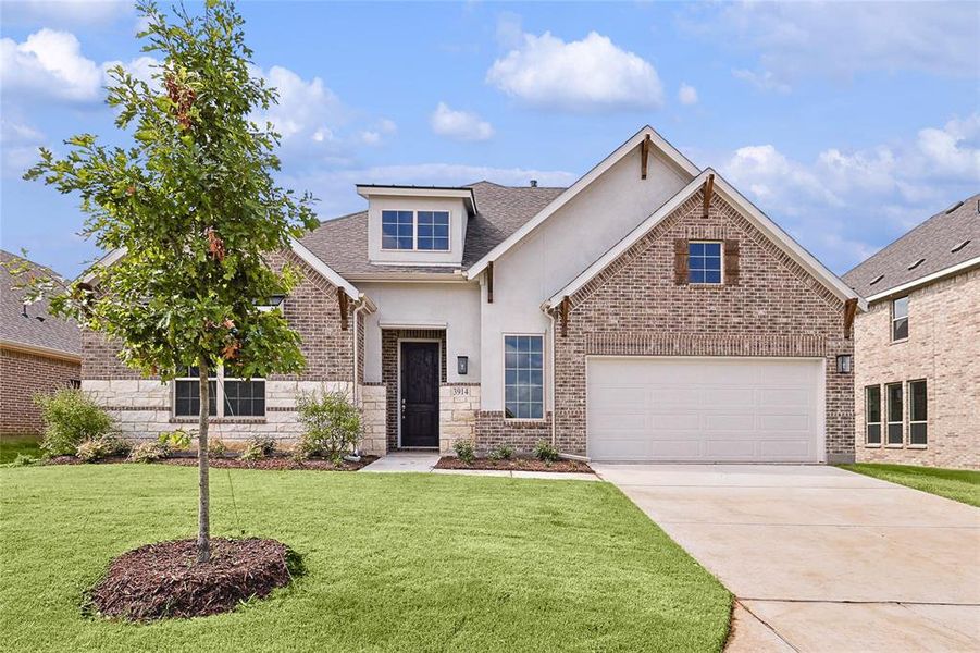 View of front of home featuring a garage and a front yard