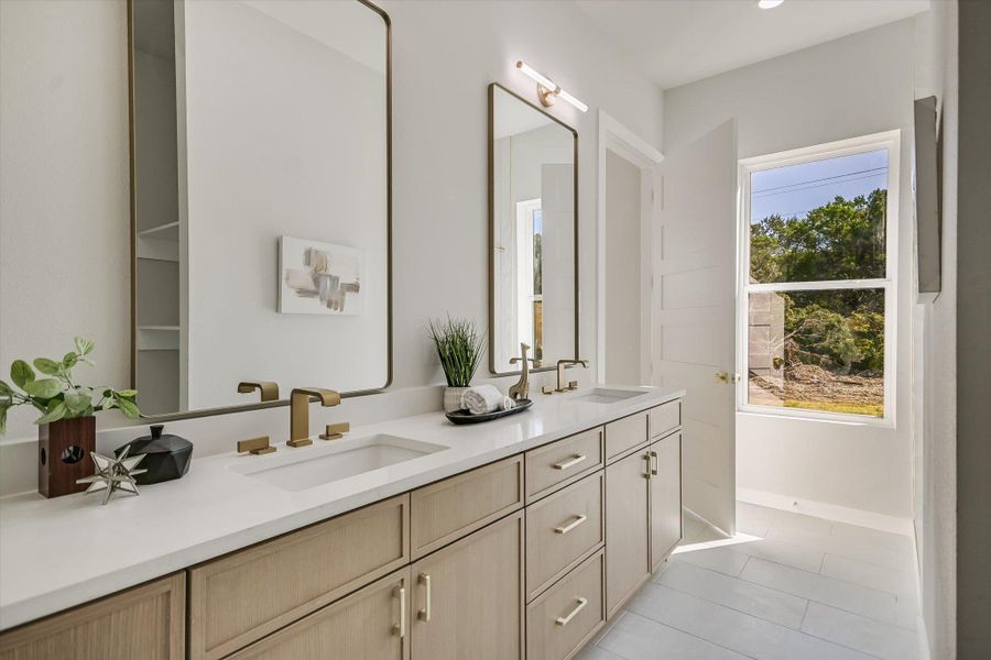Dual vanity with golden fixtures offers both style and practicality.