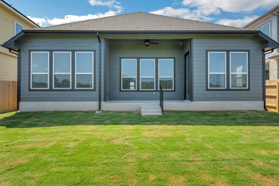 Back of property featuring a ceiling fan and roof with shingles Back of property featuring a ceiling fan and roof with shingles