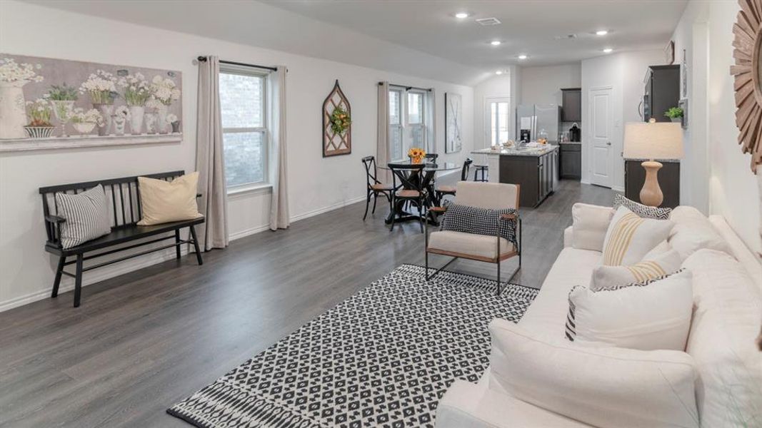 Open-concept living area featuring wood-finish flooring, recessed lighting, and multiple windows Open-concept living area featuring wood-finish flooring, recessed lighting, and multiple windows