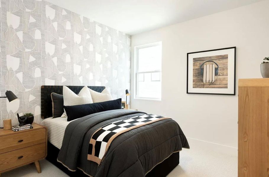 Carpeted bedroom featuring wallpapered walls and an accent wall